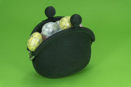 Black retro coin purse and Easter eggs on green background, Easter holiday cost conceptの写真素材