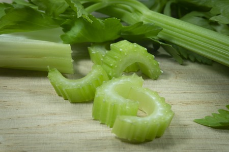 Sliced fresh celery on a cutting wooden board. Healthy eating, vegetarian food, diet, dieting...