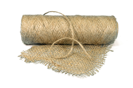 Jute fabric and spool of burlap threads isolated on whiteの写真素材