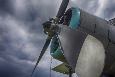 Propellers on a single engine vintage biplane viewed from the side under a cloudy skyの写真素材
