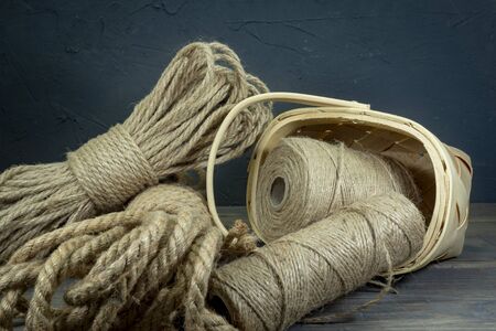 Jute rope and spools of burlap threads or jute twine in close-up on rustic wooden backgroundの写真素材