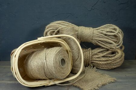 Jute rope and spools of burlap threads or jute twine in close-up on rustic wooden backgroundの写真素材