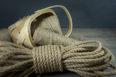 Jute rope and spools of burlap threads or jute twine in close-up on rustic wooden backgroundの写真素材