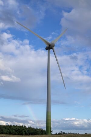 Detail of wind turbine against cloudy blue sky. Some motion blur on rotor bladesの写真素材