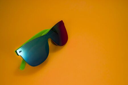 Modern colorful sunglasses on yellow background with copy space for textの写真素材
