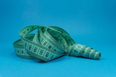 Tape measure on blue background, needlework and tailoring conceptの写真素材