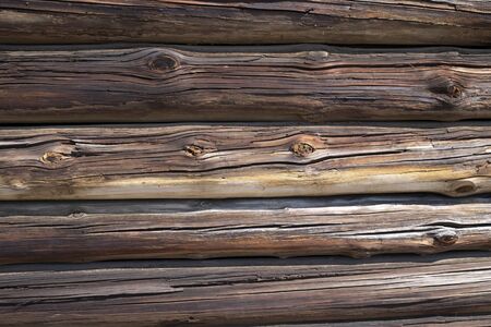 Background texture of old weathered wood cladding on a wall with natural dried planks of cracked and knotty timber in a full frame viewの写真素材