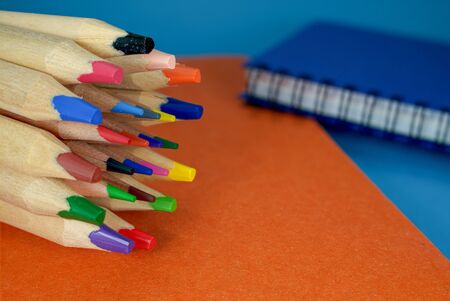 Back to school concept with colorful wooden puzzle pieces, books, pile of pencils and chalk board on...