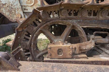 A close up of rusty steel tracks and parts on an old piece of machinery.の写真素材