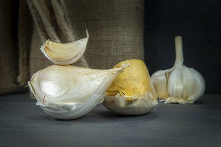 Elephant garlic (Allium ampeloprasum) regular garlic cloves on a wooden cutting boardの写真素材