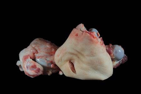 Two raw knuckle or joint bones on black, one with skin covering the bone and copy space aboveの写真素材