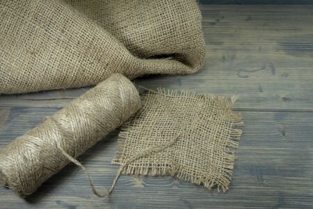 Spools of burlap threads or jute twine, sackcloth fabric in close-up on rustic grey backgroundの写真素材