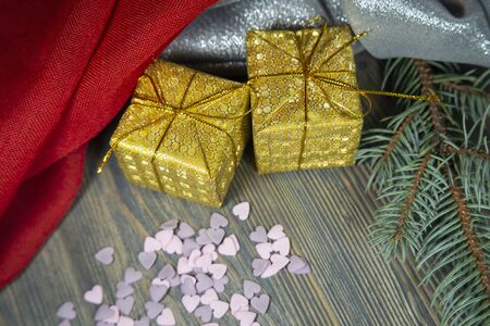 Festive Christmas background with golden gift and pine branch, colorful red drape and assorted decorationsの写真素材