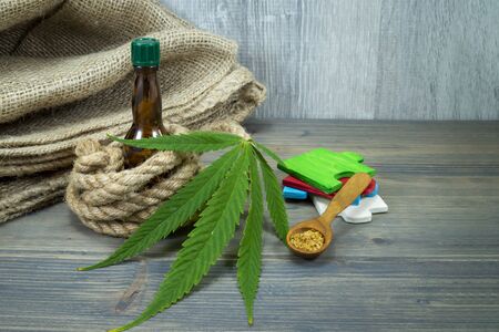 Conceptual types of cannabis products concept image with a cannabis leaf, glass decanter and natural hemp fiber ropeの写真素材