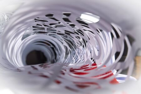 Rolled intricate homemade Christmas decoration cut from white paper in a receding abstract background view with selective focusの写真素材