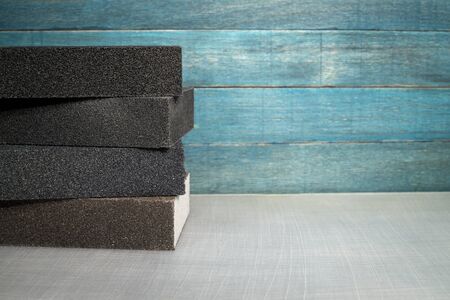 Rectangular sanding sponges in a rustic still life against a blue wooden wallの写真素材