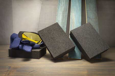 DIY renovation concept with safety gloves and goggles, abrasive sponges and plank of upright wood in close upの写真素材