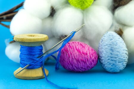 Handcrafted Easter decorations from natural cotton with a cotton bolls off the plant behind a reel...
