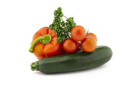 Green round courgette or zucchini, red pepper, cherry tomato twig and fresh parsley sprigs isolated on white backgroundの写真素材