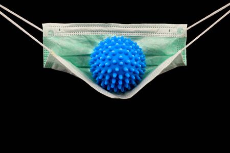 Blue virus molecule on medical face mask isolated in black backgroundの写真素材