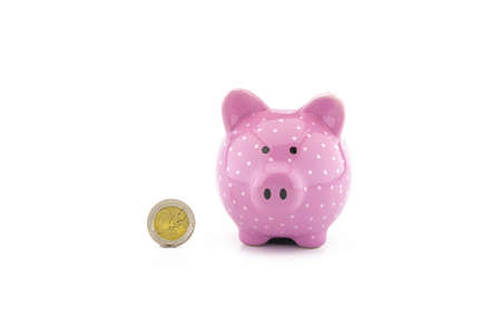 Cute pink piggy bank and euro coin on white with copyspace for financial or savings conceptsの写真素材