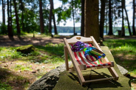 Sunglasses on a small striped deck chair in a concept of a summer vacationの写真素材