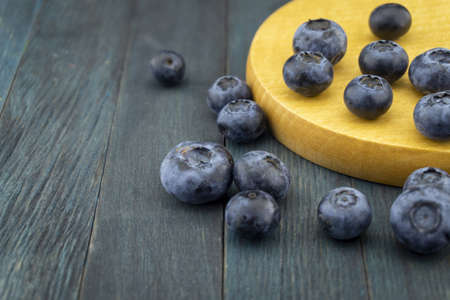 Bunch of fresh blueberries on blue rustic board, low angle selective focus and free copy space for textの写真素材
