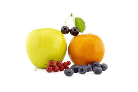 Fresh seasonal fruit still life with assorted berries including blueberries, cherries and red currants with apple and orange on a white backgroundの写真素材