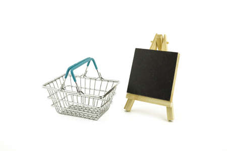 Shopping concept with shopping basket and small chalk board isolated on white backgroundの写真素材