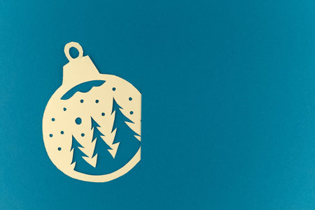 Christmas and New Year background. Small paper cut ball inserted into the slot on blue background. Holiday postcard concept with copy spaceの写真素材