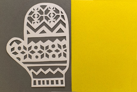 Paper cut glove on grey yellow background. Demonstrating trendy color of the year 2021. Illuminating yellow and ultimate grayの写真素材