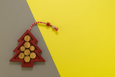 Stylized wooden Christmas tree on grey yellow background. Demonstrating trendy color of the year . Illuminating yellow and ultimate grayの写真素材