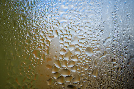 Condensation with beaded moisture droplets on the outside of a cold glass or bottle in a close up full frame background textureの写真素材