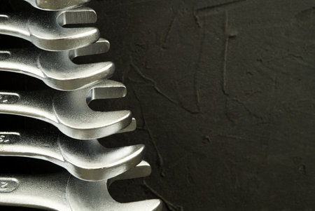 Set of spanners or wrenches in close up over a grunge stone background with free copy space