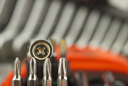 Set of interchangeable screwdriver heads with screw resting on top in selective focusの写真素材