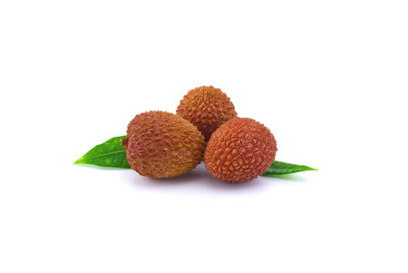 Three lychee fruit composition with green leaves decoration isolated on white backgroundの写真素材