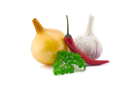Garlic bulb, green parsley twig, golden-brown onion and fresh small red chili pepper isolated on white backgroundの写真素材