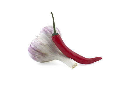 Garlic bulb and fresh small red chili pepper in close-up isolated on white backgroundの写真素材