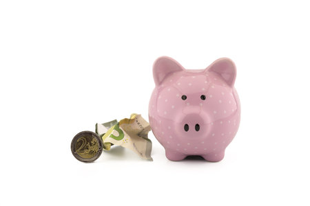 Crumpled banknotes of the euro, coins and cute pink piggy bank on white with copyspace for financial or savings conceptsの写真素材