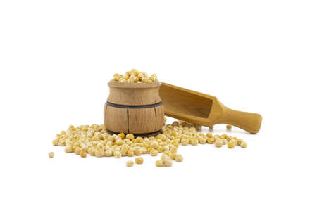 Dried peas spilling from a wooden barrel and wooden scoop isolated on a white backgroundの写真素材