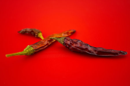 Macro image of dried red chilli pepper on red backgroundの写真素材