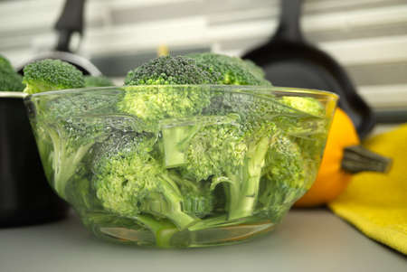 Fresh broccoli florets soaked in a clear bowl of water. Selective focus macro shotの写真素材