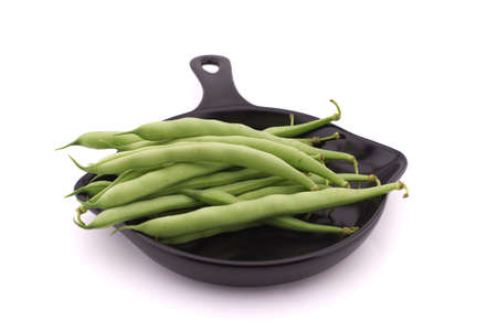 A handful of green beans in the cooking pan isolated on white background. Healthy, nutritious vegetarian foodの写真素材
