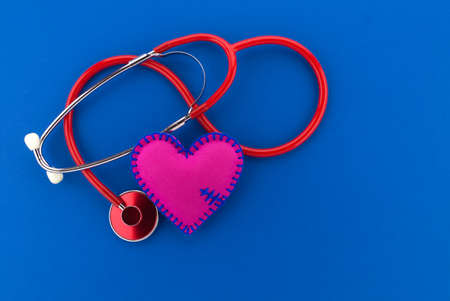Medical concept with stethoscope and red heart with copy space over blue