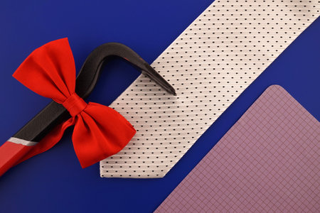 Still life with fashion accessories including an elegant necktie and red bow tie, crowbar and blank...