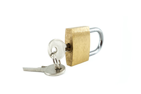 Brass lock with with keys in the hole isolated on the white backgroundの写真素材