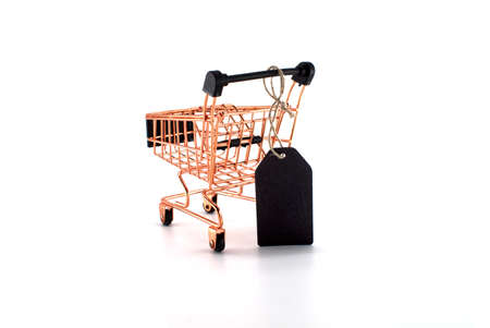 Black sale tag and golden shopping cart over white background. Black Friday sale, shopping conceptの写真素材
