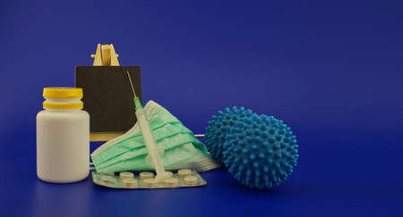 Virus pandemic and possible vaccine concept with surgical mask, hypodermic syringe, pharmaceutical bottle small chalk board and blue virus molecules in a panoramic format with copy space for textの写真素材