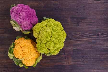 Colorful cauliflowers, fresh colorful cauliflowers over a rustic wood background with copy space viewed top down. Healthy eatingの写真素材
