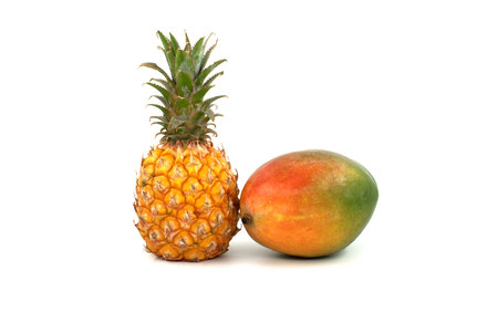 Whole pineapple fruit and multicolored mango isolated on a white backgroundの写真素材